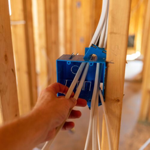 Hand working on electrical wires in new home construction
